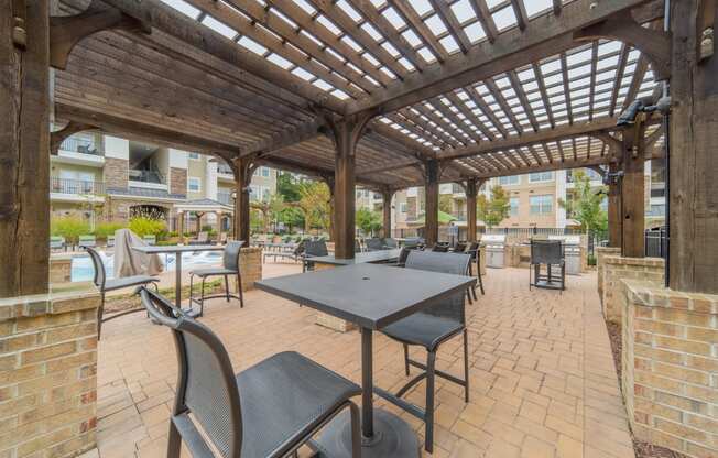 a patio with tables and chairs and a pergola
