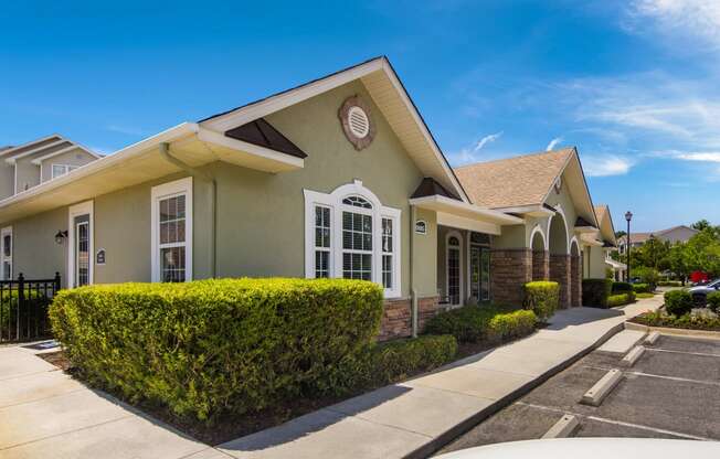 Well-maintained clubhouse exterior surrounded by lush landscaping at Angel Landing apartments in Pensacola, FL