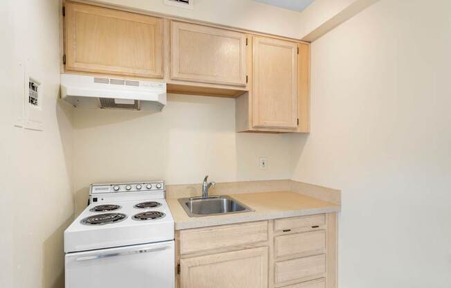 a kitchen with white appliances and wooden cabinets