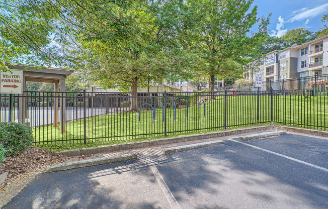 a basketball court in front of a fence and trees