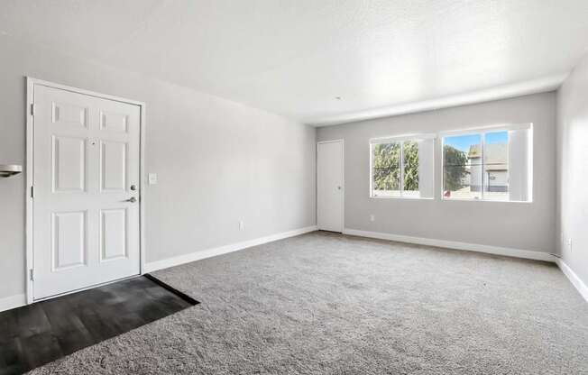 A room with a white door and carpeted floor.