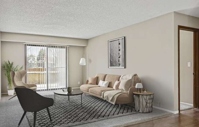 a living room with a beige couch and a black and white rug