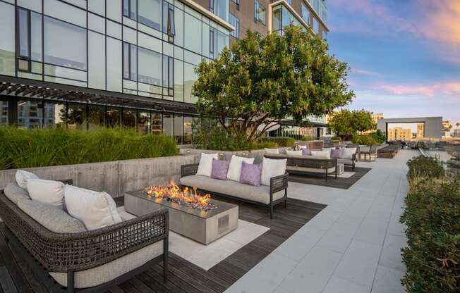 A patio with a fire pit and couches.
