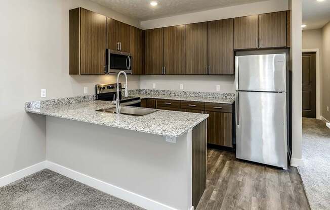 A kitchen with a granite countertop and stainless steel appliances.