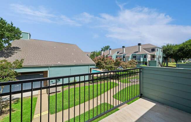 A house with a green roof and a black fence.
