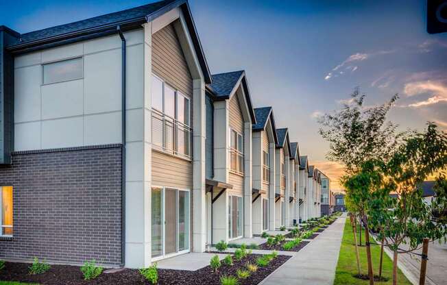 a row of townhouses with a sidewalk in front of them