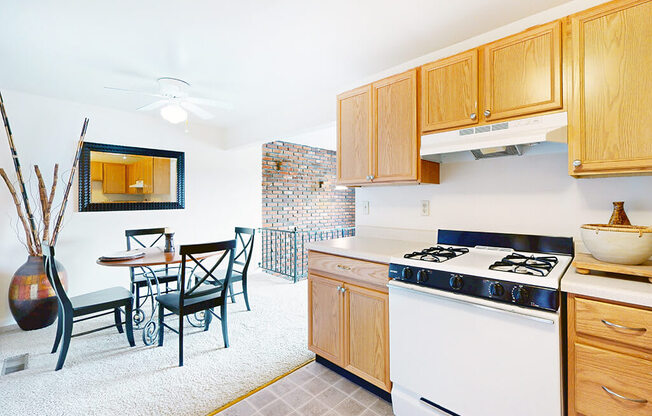 A kitchen with a white stove and wooden cabinets.