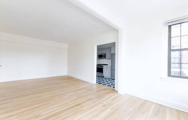 vacant living area with hard wood flooring and view of kitchen at the dahlia apartments washington dc
