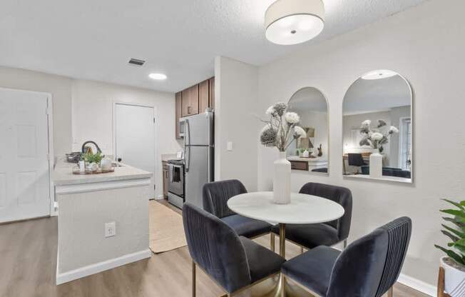 A kitchen with a dining table and chairs.