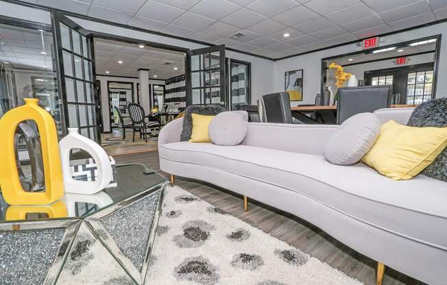 Modern resident lounge in leasing office with a grey sofa and a glass coffee table at Maplewood apartments in Shreveport, LA.