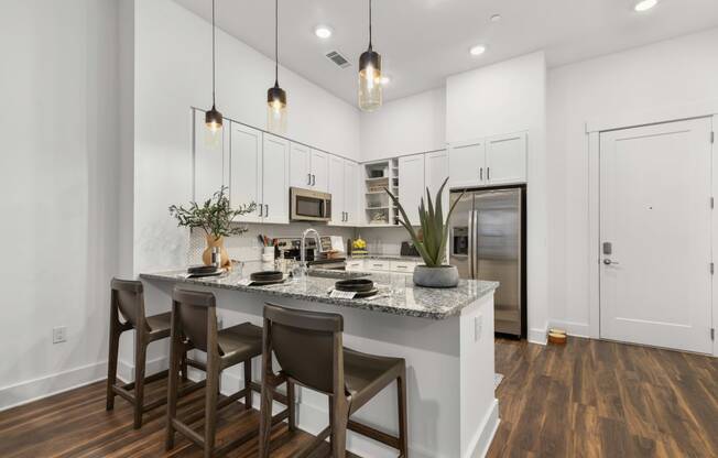 a kitchen with a large island with three stools at The Colony, Charlotte, 28211