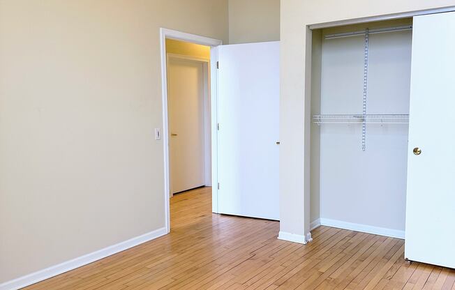 an empty living room with wood floors and a closet