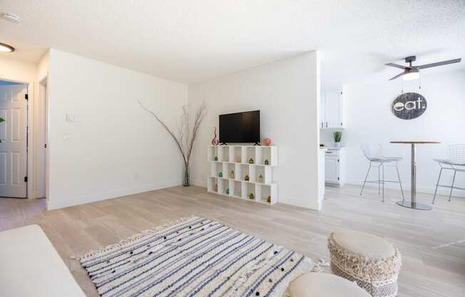 a living room with a tv and a dining room with chairs and a rug at Campbell West Apartments, Campbell, CA 95008