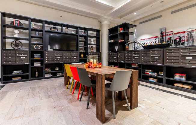 a dining room with a table and chairs and a tv in a room with shelves