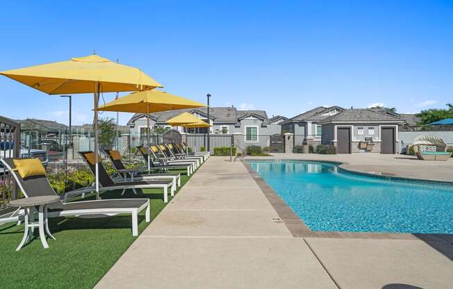a pool with lounge chairs and umbrellas next to a pool