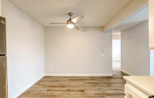 an empty kitchen and living room with a ceiling fan