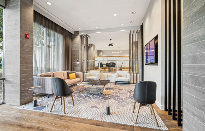 A modern living room with a black chair in the foreground.