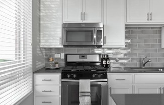 A modern kitchen with white cabinets and a black and white color scheme.