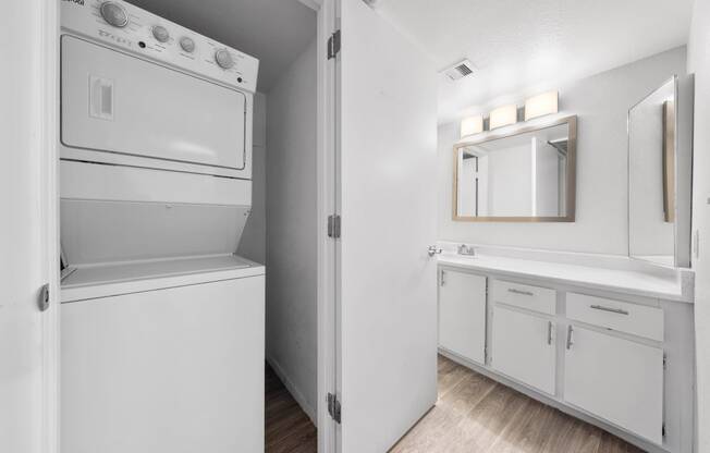 a white laundry room with a washer and dryer and a sink
