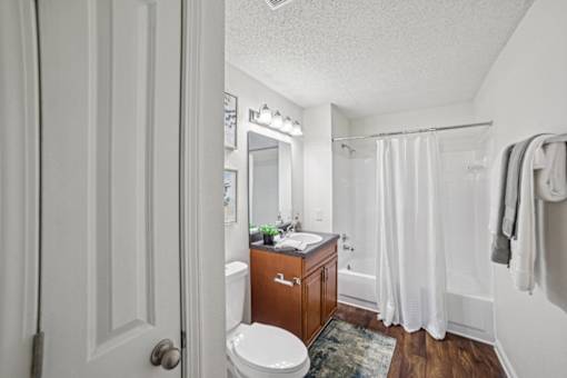 A white bathroom with a toilet, sink, and shower.