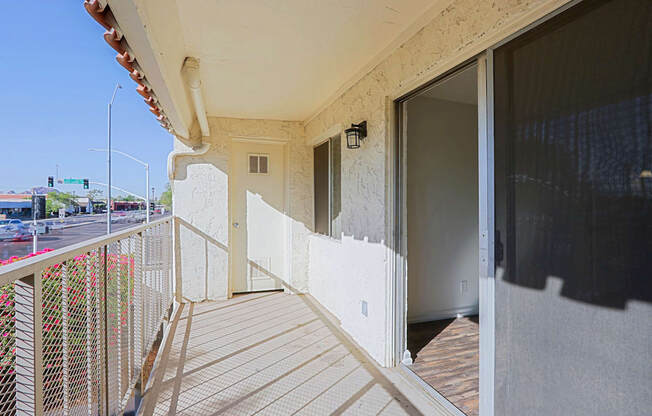 A balcony with a railing and a view of the street below.