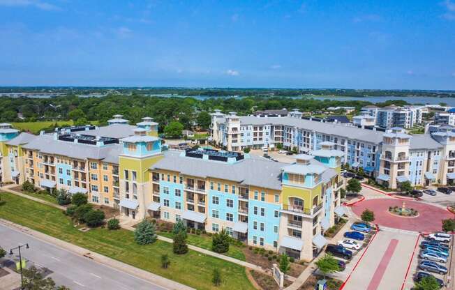 an aerial view of an apartment complex with a lake in the background