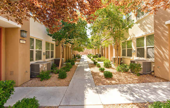 A row of houses with trees and bushes in front.