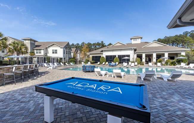 a pool with a table in front of a house