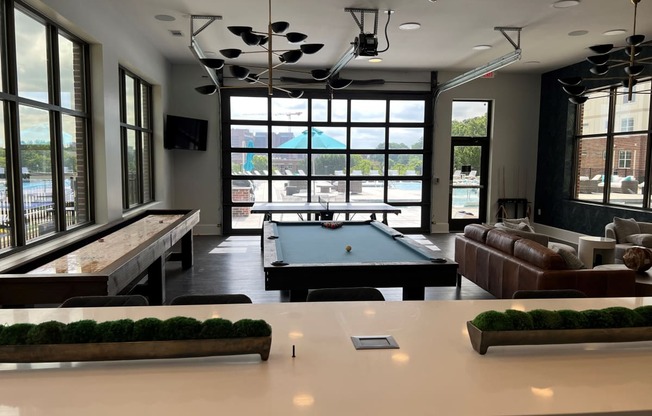 a large room with a pool table and couches