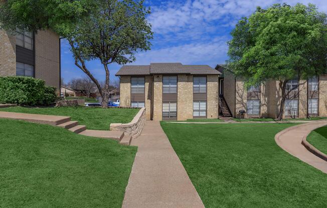 a large lawn in front of a brick building