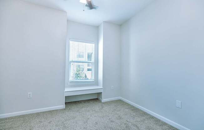 A room with a window and a ceiling fan.