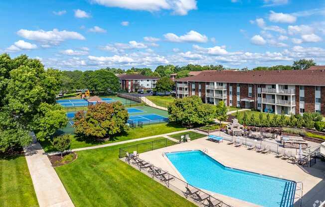 A large swimming pool surrounded by a grassy area and trees.