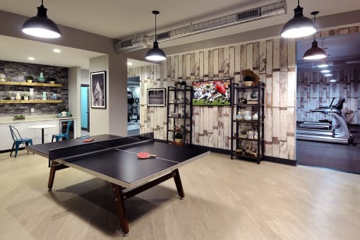 a games room with a ping pong table and a television at Willowest in Collier Hills, Atlanta, Georgia