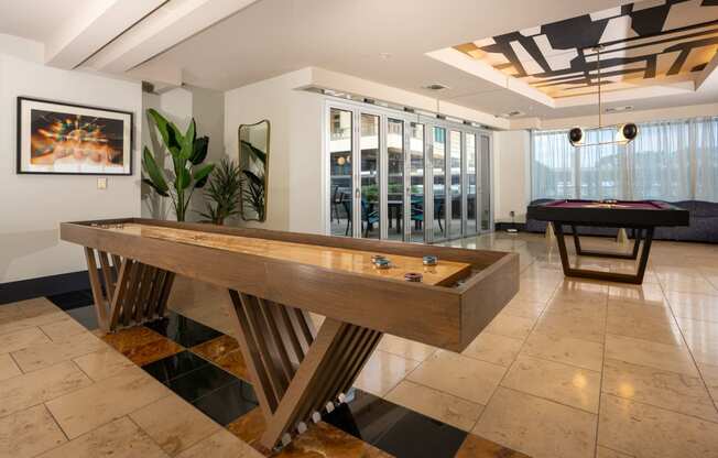 a game room with a shuffleboard table and a pool table