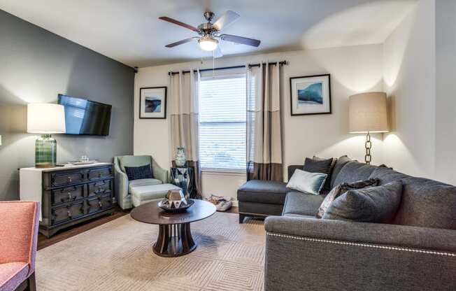 a living room with a couch and chair and a ceiling fan