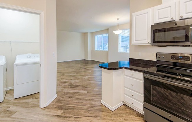 an empty kitchen with a washer and dryer in it