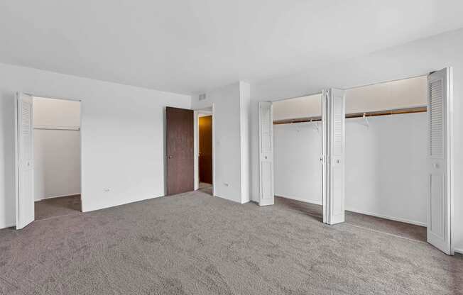 a bedroom with white walls and carpet