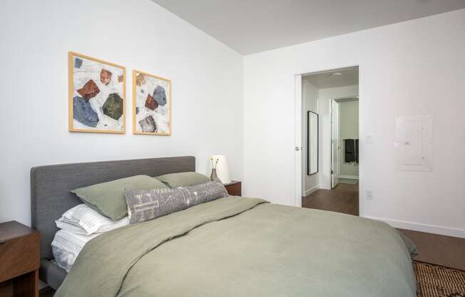 a bedroom with a large bed and two paintings on the wall at Slabtown Square Apartments, Portland , OR
