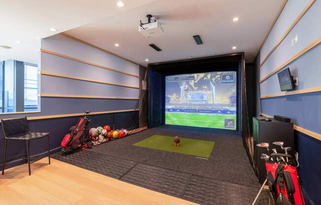 a game room with a projector screen and a ball on the floor