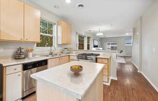 a large kitchen with an island with a bowl of fruit