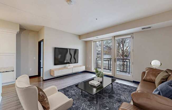 A living room with a brown couch, a white chair, and a glass coffee table.