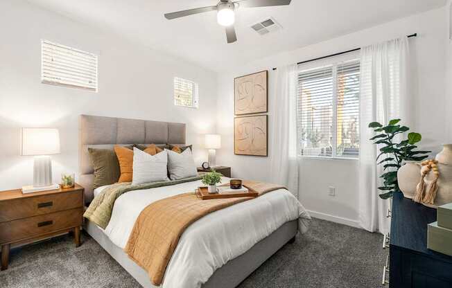 A bedroom with a large bed and a ceiling fan.