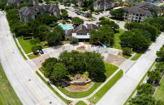 A park with a playground and a swimming pool is surrounded by houses.