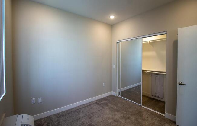 a room with a carpeted floor and a door to a bathroom at Loma Villas Apartments in San Bernardino, CA