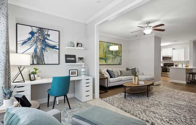A modern living room with a blue chair and a white desk.
