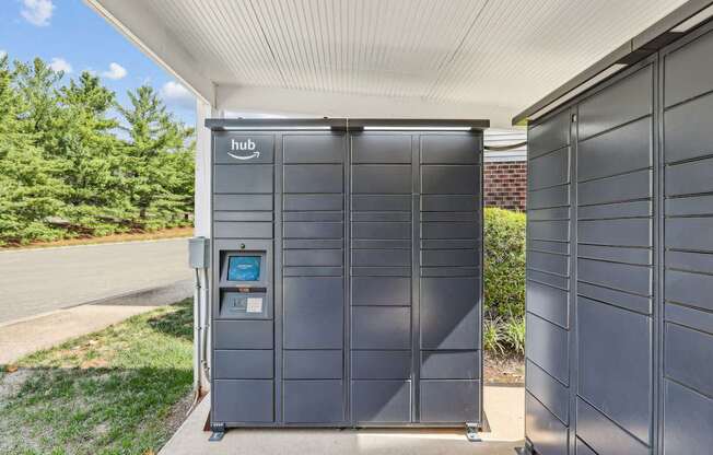 A grey Amazon Hub box is on the sidewalk.