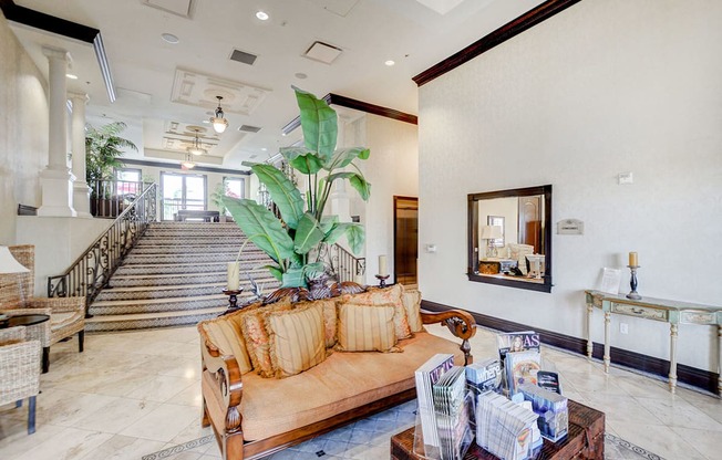 A living room with a couch, coffee table, and a staircase.