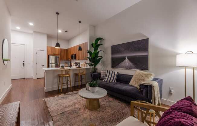 Dog-Friendly Apartments in Old East Dallas, TX - 4600 Ross - Living Room with Hardwood-Style Flooring, Modern Light Fixtures, and Open-Concept Layout with Kitchen