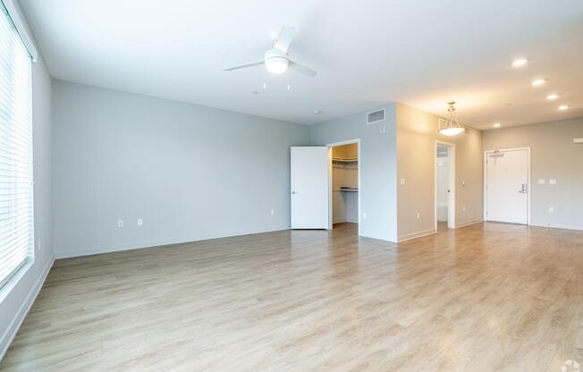 A spacious room with a ceiling fan and lighting fixtures.