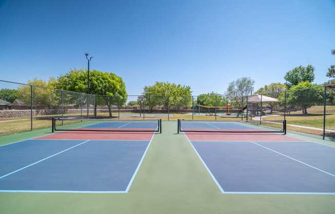 a tennis court with four tennis courts on it on a sunny day